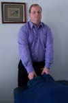 Reiki practitioner lightly touches the client's ankles.