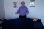 Reiki practitioner fluffs energy upward, away from the client, to fill her aura.