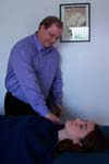 Reiki practitioner taps the client's shoulder.